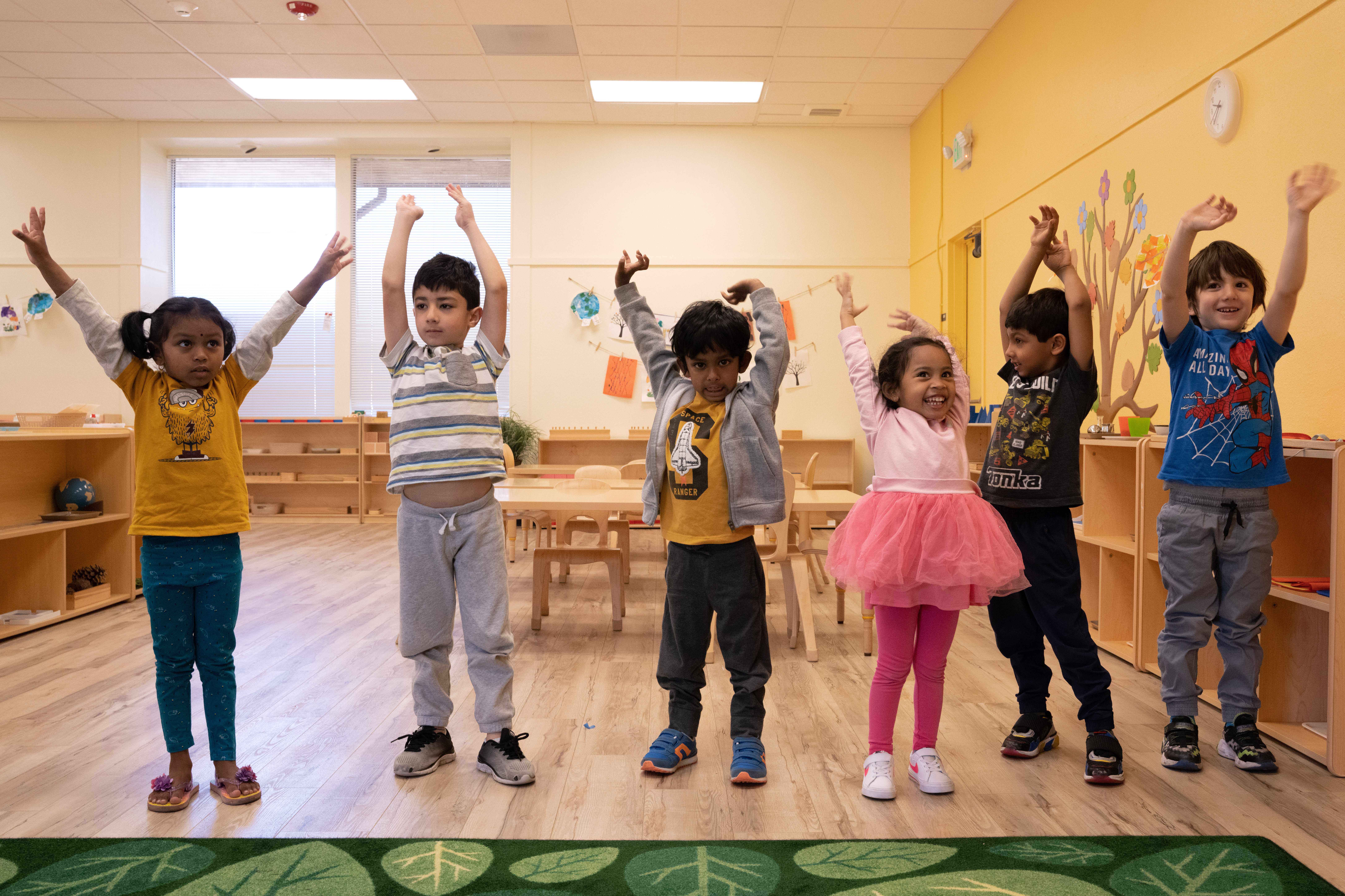 kids standing up with their arms up stretching