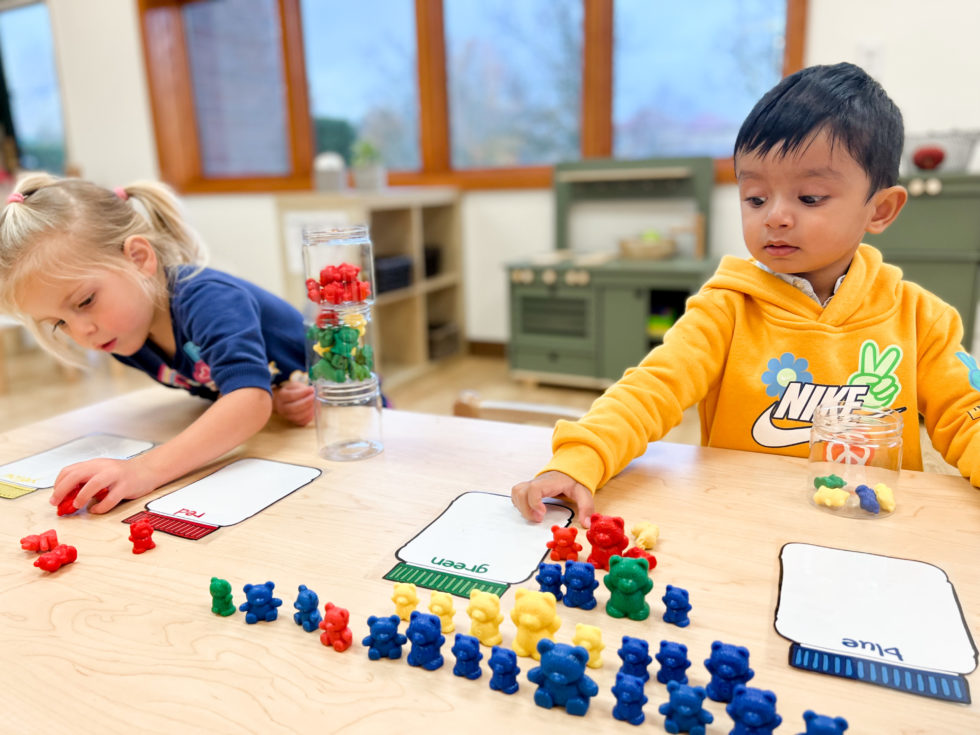 2 kids playing with colored bears