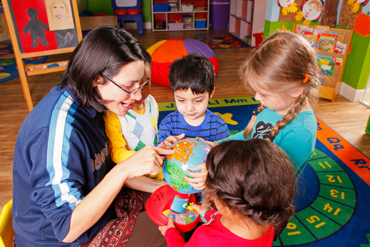 teacher showing kids a globe